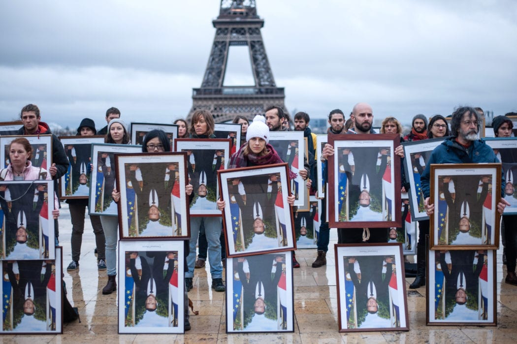 Action 100 portraits retournés de Macron devant la tour Eiffel